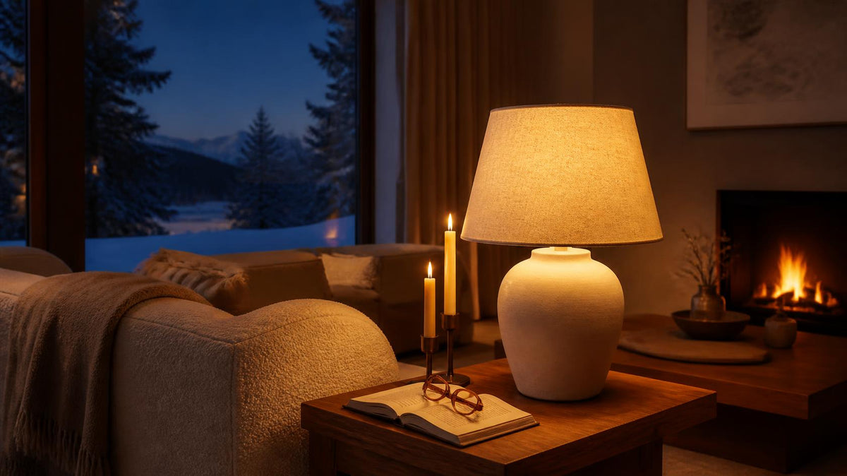 Lamp glowing amber in a living room at winter dusk